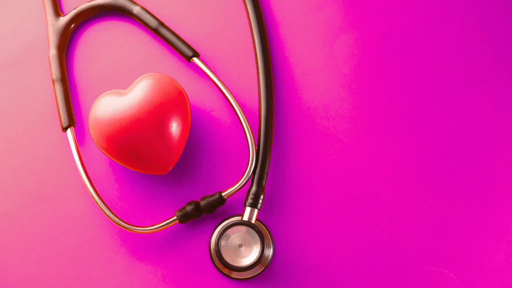 Stethoscope wrapped around a red heart on a vibrant pink background, symbolizing health care.