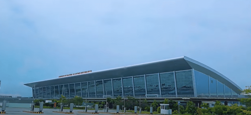 Exterior view of the Dr. António Agostinho Neto International Airport in Luanda, Angola – modern glass terminal with visible signage under a clear sky.