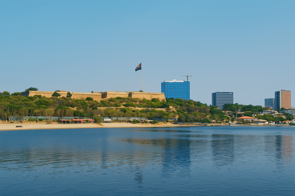 View of São Miguel Fortress in Luanda, Angola, with the Angolan flag and city skyline in the background, seen from the bay.