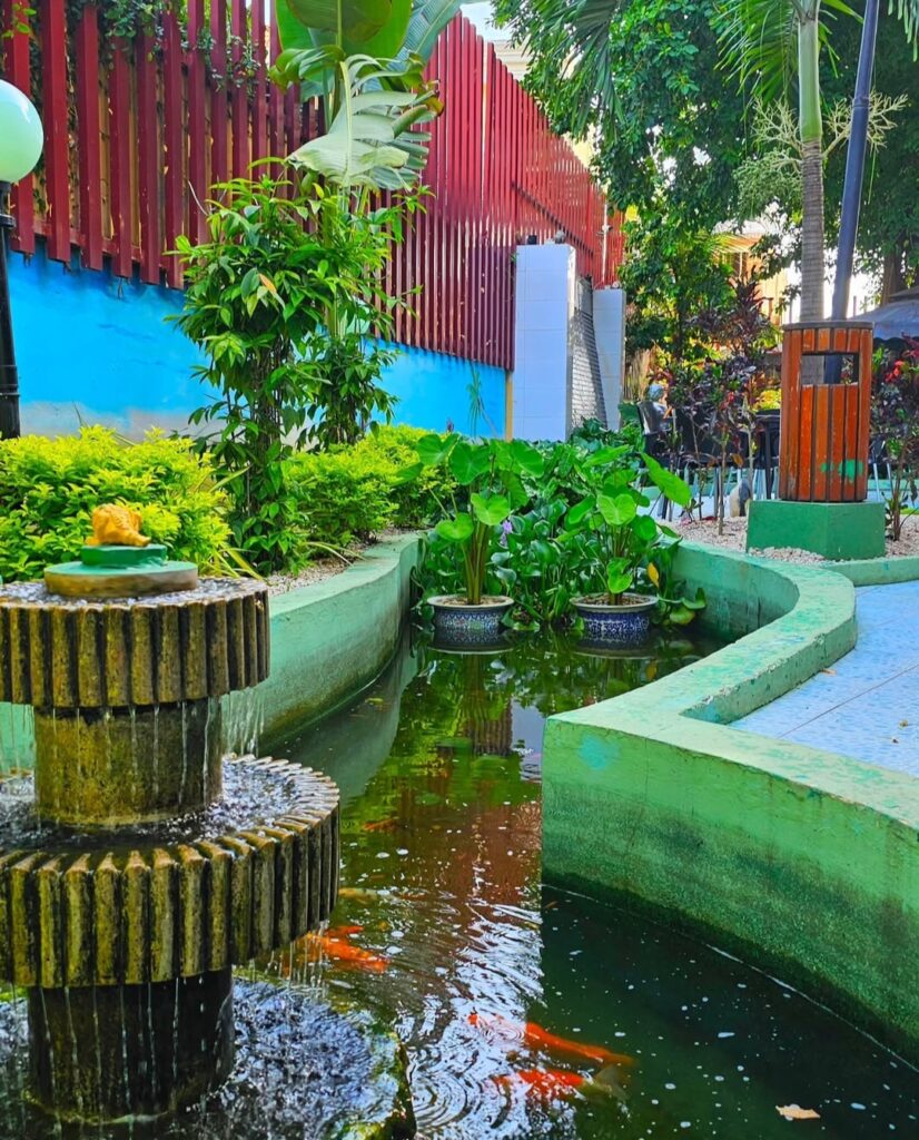 Garden pond with koi fish and a decorative water fountain at the outdoor area of Hao Yun Lai, a Chinese restaurant in Luanda.