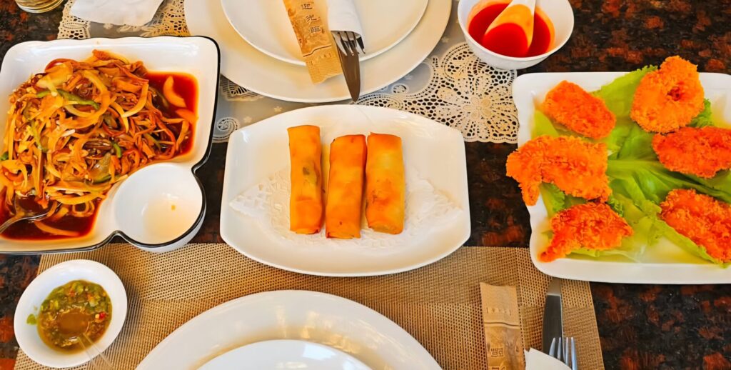 Chinese appetizers including crispy spring rolls, stir-fried vegetables and deep-fried chicken served at Hao Yun Lai restaurant in Luanda.