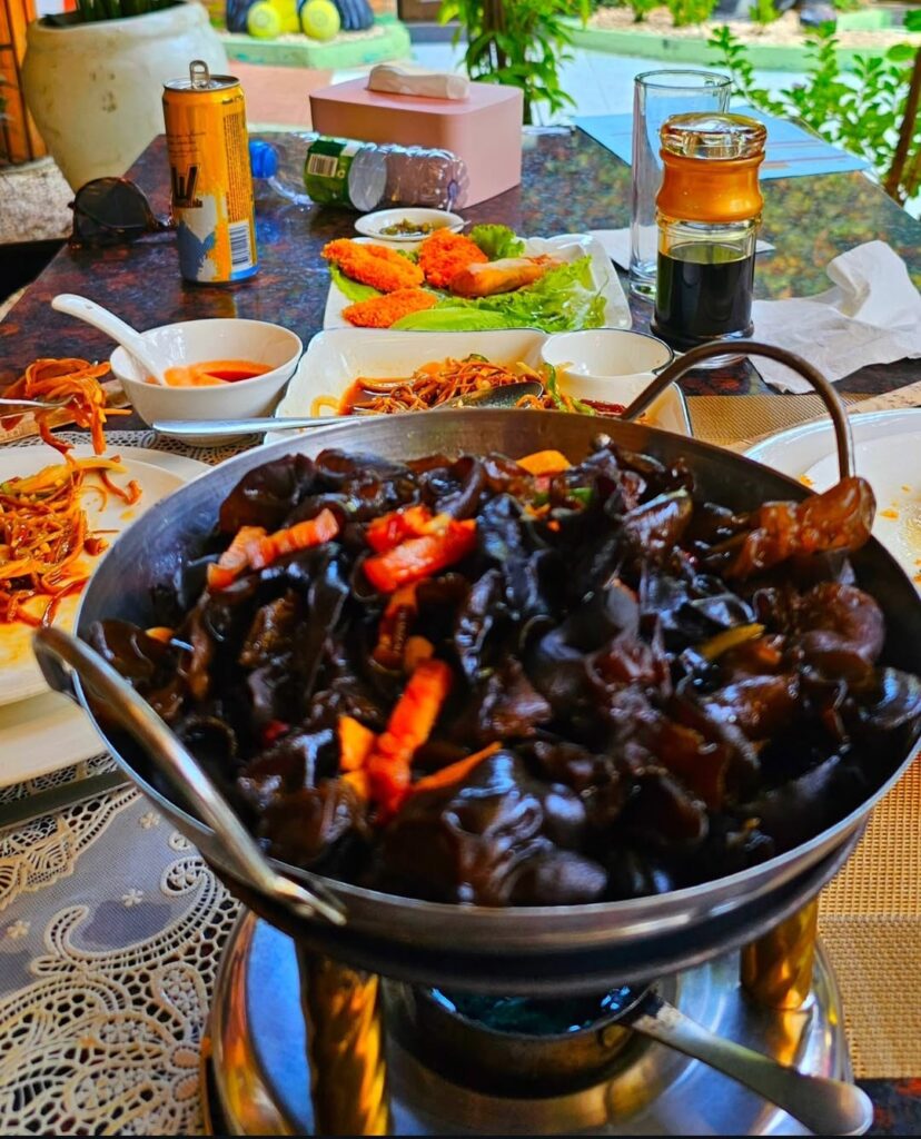 Chinese-style hot pot with black fungus mushrooms and vegetables, served in a traditional metal pot at Hao Yun Lai restaurant in Luanda.