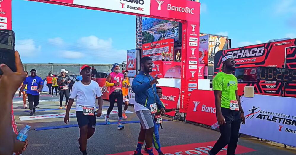 Finish line at the Tchaco Sports 10K race in Luanda, Angola, with runners arriving under the event banner after a challenging course of hills and turns. A celebration of movement, community, and athletic spirit.