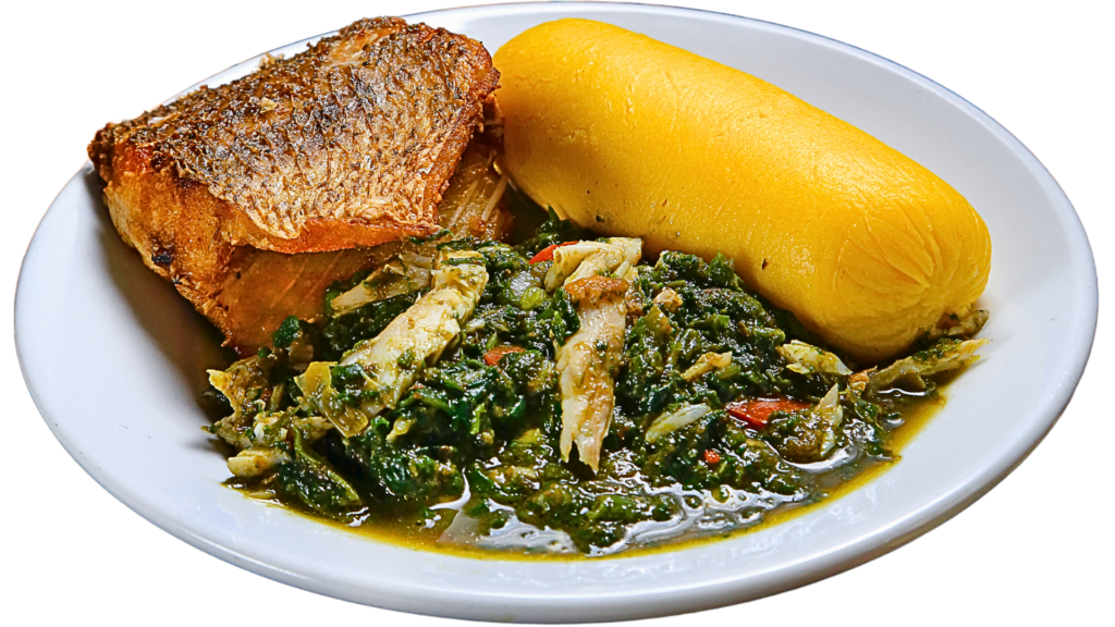 Plate of Angolan Calulu with sautéed greens and shredded fish in a rich sauce, served with grilled fish and a portion of yellow corn funge on the side.