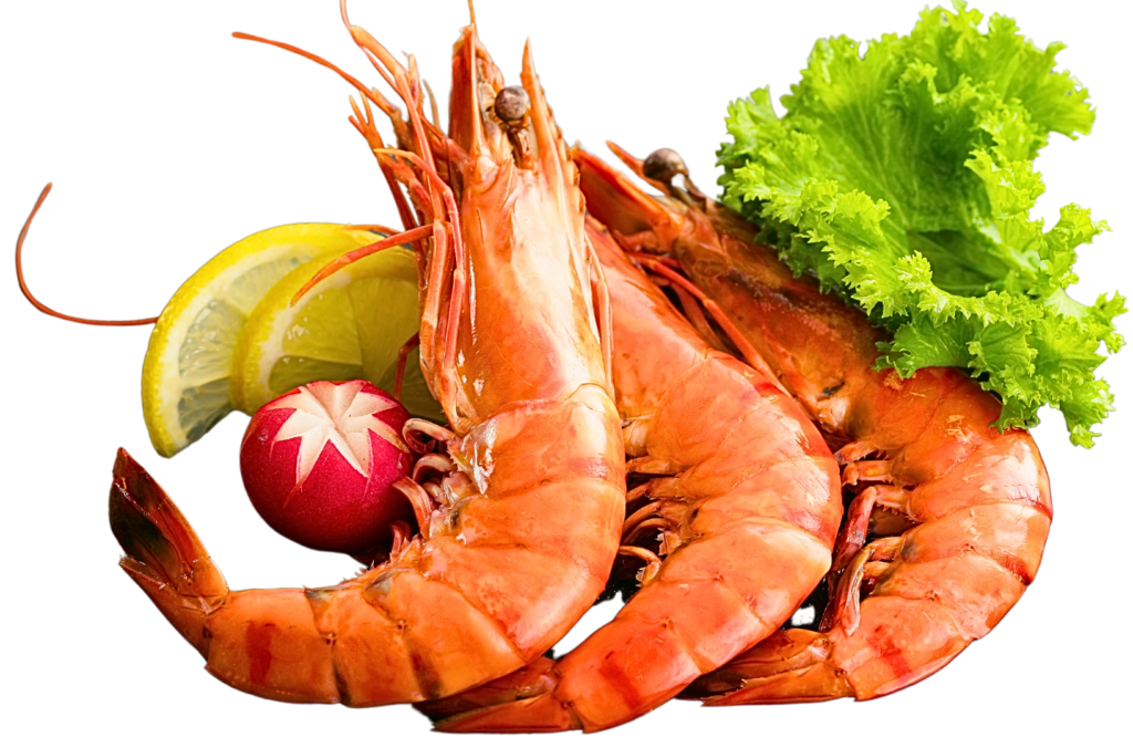 Three cooked prawns served with fresh green lettuce, lemon slices, and a decorative carved radish, isolated on a black background