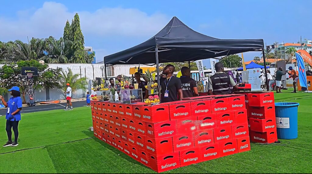 Juice and smoothie stand at the Talatona Fitness Fair 2025, with vibrant fruit displays and Refrige-branded crates creating a lively and refreshing corner at the event.