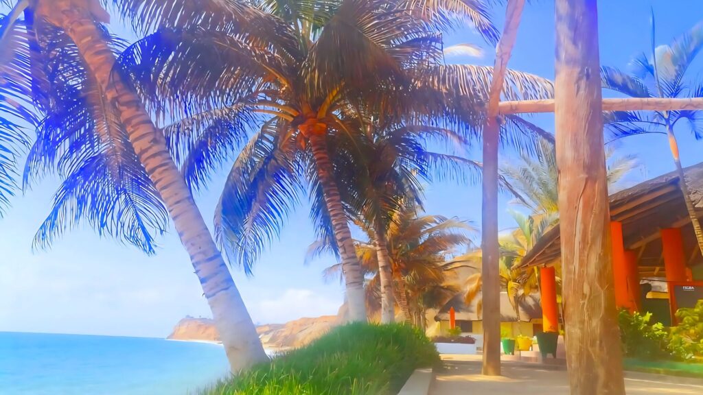 Tropical beachside view in Angola with tall palm trees, ocean waves and a thatched-roof beach bar creating a relaxing paradise atmosphere.